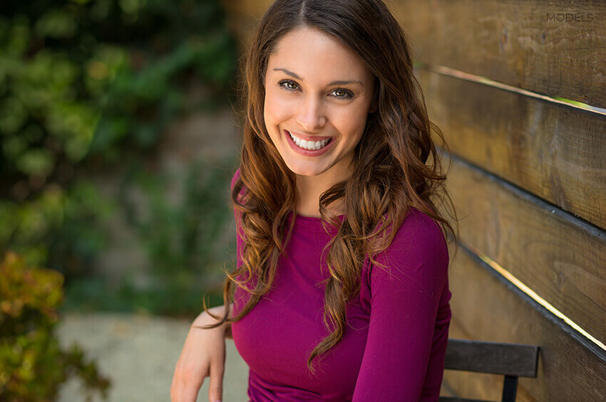 Young-Woman-Sitting-and-Smiling-at-Camera