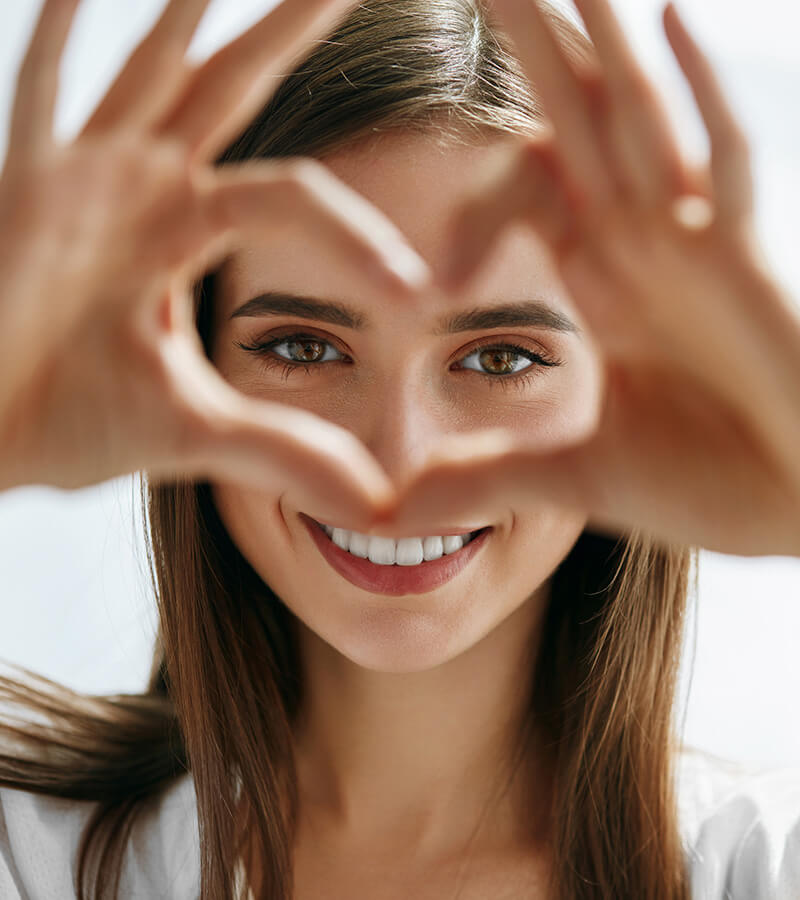 woman holding her hand in the shape of a heart